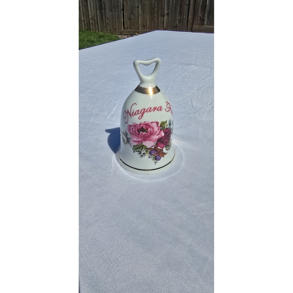 Niagara Falls souvenir bell is ceramic & decorated with pink roses and gold trim